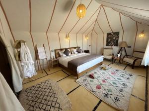 a bedroom with a bed and a rug in a room at Camp Sakura Desert Dream in Merzouga