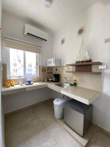eine kleine Küche mit einem Waschbecken und einem Fenster in der Unterkunft Casa Coronaa Holbox México in Holbox