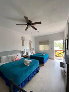 een slaapkamer met 2 bedden en een plafondventilator bij Casa Coronaa Holbox México in Holbox Island