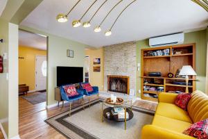 - un salon avec un canapé jaune et une cheminée dans l'établissement Lake View Cottage Retreat, à Bemus Point