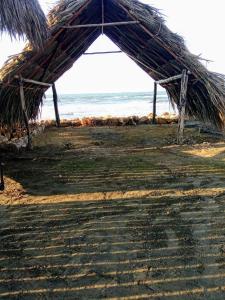a straw hut on the beach near the ocean at AGUAMARINA House in San Bernardo del Viento