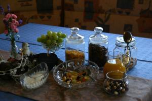 a table topped with bowls of fruit and jars of food at Pension Hoisl in Schönberg