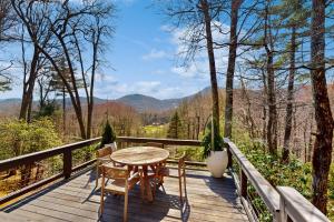 a table and chairs on a wooden deck with a view at Cashmere Cottage in Cashiers