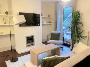 a living room with a fireplace and a tv at London Townhouse 1-Bed Apartment with Garden in Tufnell Park near Emirates Stadium and 10 mins to Kings Cross in London