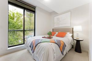 a bedroom with a bed and a large window at Fabulous 2Bdr Duplex in Yaletown in Vancouver