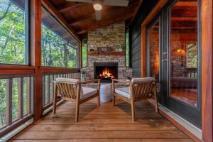 a screened porch with two chairs and a fireplace at Moonshine Overlook in Blue Ridge