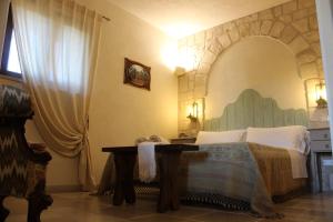 1 dormitorio con 1 cama grande y 1 mesa en Masseria Tolla, en Ostuni