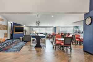 uma sala de jantar com mesas e cadeiras e um relógio em Best Western Westgate Inn em York