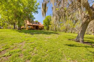 una casa con un árbol delante de un patio en Waterfront Livingston Log Cabin with Private Dock!, en Blanchard