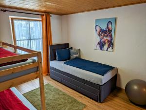 a bedroom with a bed and a dog painting on the wall at Ferienwohnung Alpenblick Dorner in Oberreute