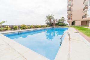 una piscina con agua azul en un edificio en Piso con vista increíble al mar, en Sant Andreu de Llavaneres