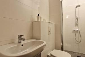 biała łazienka z umywalką i prysznicem w obiekcie Große, geräumige Unterkunft für bis zu 13 Personen! w Lipsku