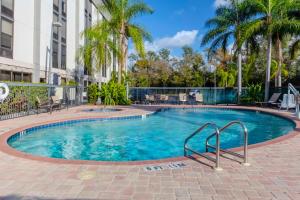 a swimming pool with palm trees and a building at Hampton Inn Sarasota I-75 Bee Ridge in Sarasota