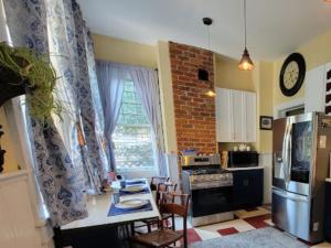 a kitchen with a table and a kitchen with a refrigerator at The Kings Throne Inn and Guest House in Toledo