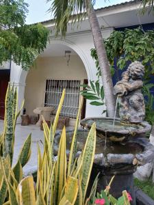 Una statua di una scimmia seduta accanto a una fontana. di Hostel Mamy Dorme a Barranquilla