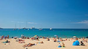 un grupo de personas en una playa con el océano en 2 pièces à 5min de Cannes, en Le Cannet