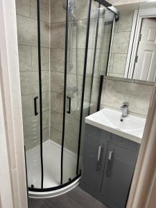 W łazience znajduje się prysznic i umywalka. w obiekcie ELSARO guest house w mieście Slough