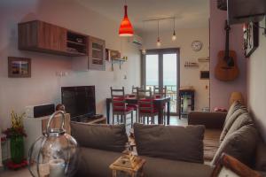 sala de estar con sofá y cocina con mesa en Luxury Apartment, en Messina