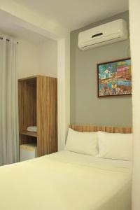 um quarto com uma cama com um lençol branco em Hotel Serras De Goyaz Bueno, Goiânia em Goiânia