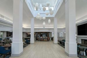 - une vue sur une bibliothèque avec des colonnes et des chaises blanches dans l'établissement Hilton Garden Inn Detroit Metro Airport, à Romulus