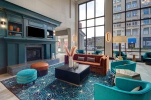 a lobby with a living room with a fireplace at Hilton Garden Inn Terre Haute in Terre Haute