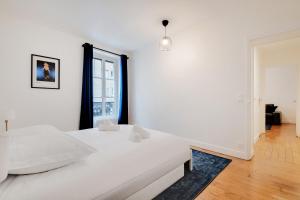 um quarto branco com uma cama e uma janela em Beautiful Luxury Appartement em Levallois-Perret