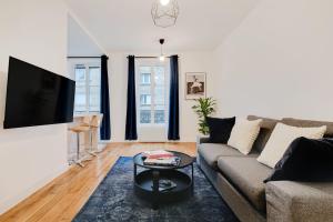 uma sala de estar com um sofá e uma televisão de ecrã plano em Beautiful Luxury Appartement em Levallois-Perret