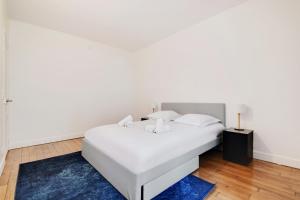 um quarto com uma cama branca e um tapete azul em Beautiful Luxury Appartement em Levallois-Perret