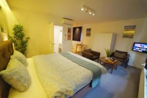 a bedroom with a large bed and a living room at Arku apartments Brussels Airport in Zaventem