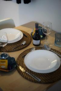 - une table avec deux assiettes et des verres à vin dans l'établissement Arku apartments Brussels Airport, à Zaventem