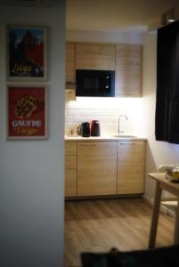 a kitchen with wooden cabinets and a sink at Arku apartments Brussels Airport in Zaventem