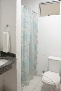a bathroom with a toilet and a shower curtain at Hotel Serras De Goyaz Bueno, Goiânia in Goiânia