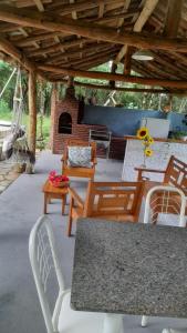d'une terrasse avec une table, des chaises et une cheminée. dans l'établissement Sítio São Benedito, à Pirenópolis