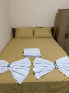 a bed with two white towels on top of it at Pousada Lençóis Encantados - Centro de Barreirinhas in Barreirinhas