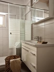 a white bathroom with a sink and a shower at Avesta Villas in Vlikhon