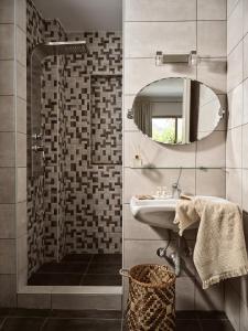 a bathroom with a sink and a shower with a mirror at Avesta Villas in Vlikhon