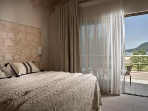 a bedroom with a bed and a large window at Avesta Villas in Vlikhon