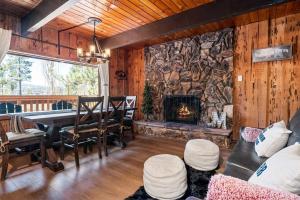 ein Wohnzimmer mit einem Tisch und einer Steinmauer in der Unterkunft Cozy Cabin near Resorts and The Village +Mtn views in Big Bear City