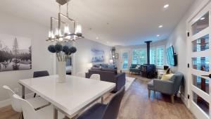 a dining room and living room with a white table and chairs at 2BR Renovated Townhouse in Benchlands by Harmony Whistler in Whistler