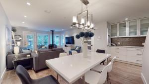 a kitchen and living room with a white table and chairs at 2BR Renovated Townhouse in Benchlands by Harmony Whistler in Whistler