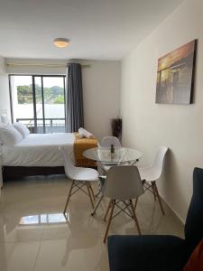 a bedroom with a bed and a table and chairs at Luxurious Millennium, uMhlanga Durban in Durban