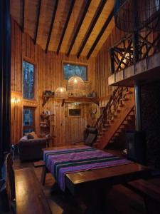 1 dormitorio con 1 cama en una habitación de madera en El Refugio de Hadas y Elfos, en Puerto Fuy