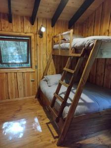 a room with two bunk beds in a cabin at El Refugio de Hadas y Elfos in Puerto Fuy