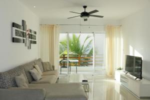 a living room with a couch and a ceiling fan at Marina Excelsior in Playa del Carmen