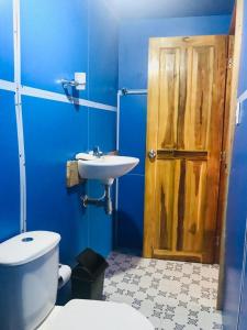 WonderBeach Baru Raquel في بارو: حمام ازرق مع مرحاض ومغسلة