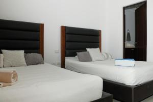 2 Betten nebeneinander in einem Zimmer in der Unterkunft Marina Excelsior in Playa del Carmen