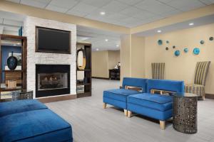 a waiting room with blue couches and a fireplace at Hampton Inn Syracuse Clay in Liverpool