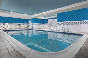 a large swimming pool with chairs in a building at Hampton Inn Syracuse Clay in Liverpool