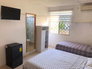 a small bedroom with two beds and a window at Pargo, habitación privada de Flor de Lis Beach House in Playas