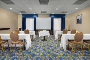 a conference room with tables and chairs and a screen at Hampton Inn Syracuse Clay in Liverpool